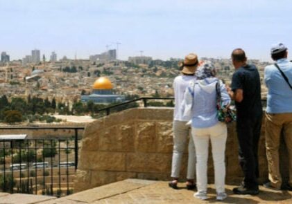 The guide shows the Jerusalem Old City view to the tourists and pilgrims. Mount of Olives is a famous Holy Land place and it has a fantastic view to the Old Jerusalem